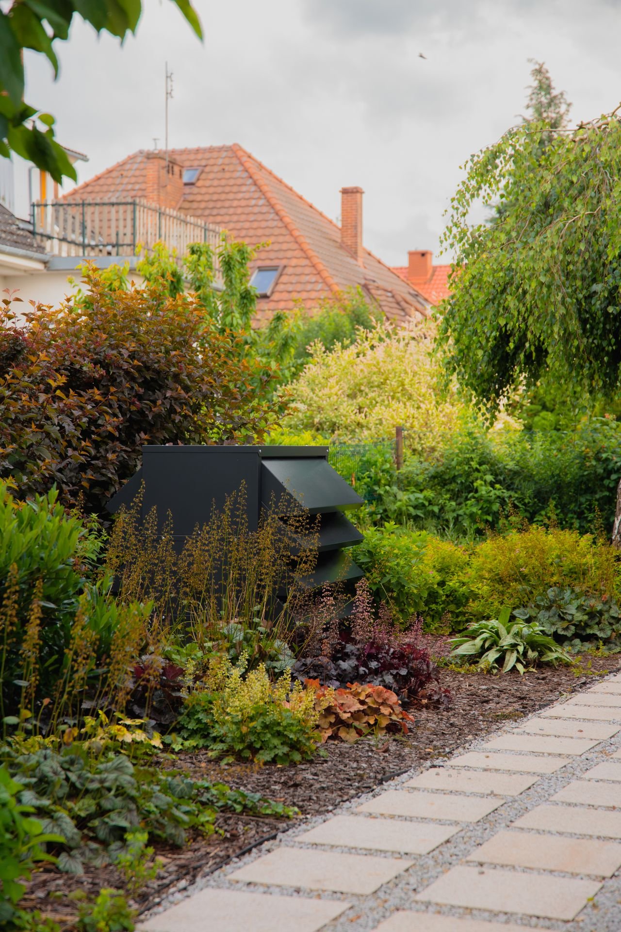 Wärmepumpe im Garten inmitten von Grünflächen mit schalldämmendem Gehäuse für die Wärmepumpe