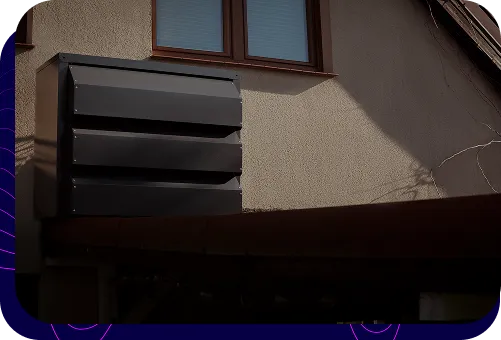 Eine moderne, dunkle Silencions s|AC|-Schallschutzhaube, die an der Wand eines Wohngebäudes montiert ist und die Außeneinheit der Klimaanlage abdeckt.