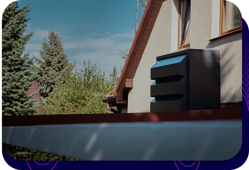 Eine moderne, graphitfarbene Schallschutzhaube Silencions s|AC|, die an der Wand eines Wohngebäudes montiert wird, dämpft effektiv die Geräusche der Klimaanlage und verbessert die Ästhetik der Installation.