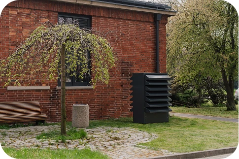 Die moderne Akustikverkleidung Silencions s|HP| vor dem Hintergrund eines Backsteinwohnhauses sorgt für Ruhe und ein ästhetisches Erscheinungsbild in der Wohnsiedlung.
